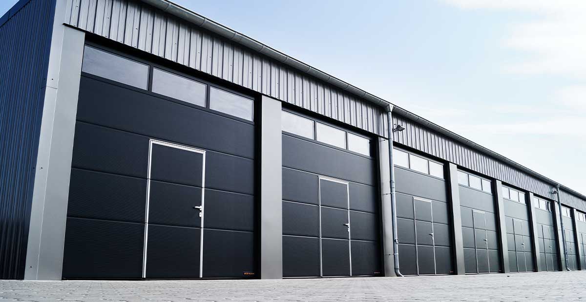 RME | Assetklasse Industrial: Lagerhallen von außen mit schwarzen Toren, blauer Himmel