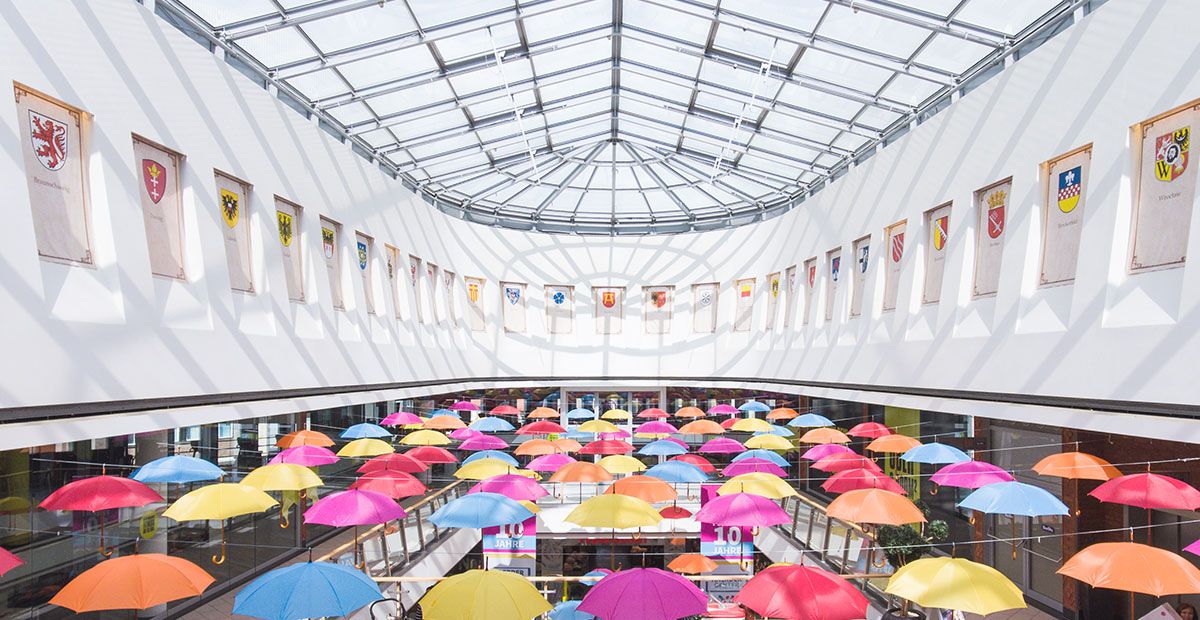 RME | Assetklasse Retail | Innenansicht von Oberlicht mit Dekoration aus bunten Regenschirmen