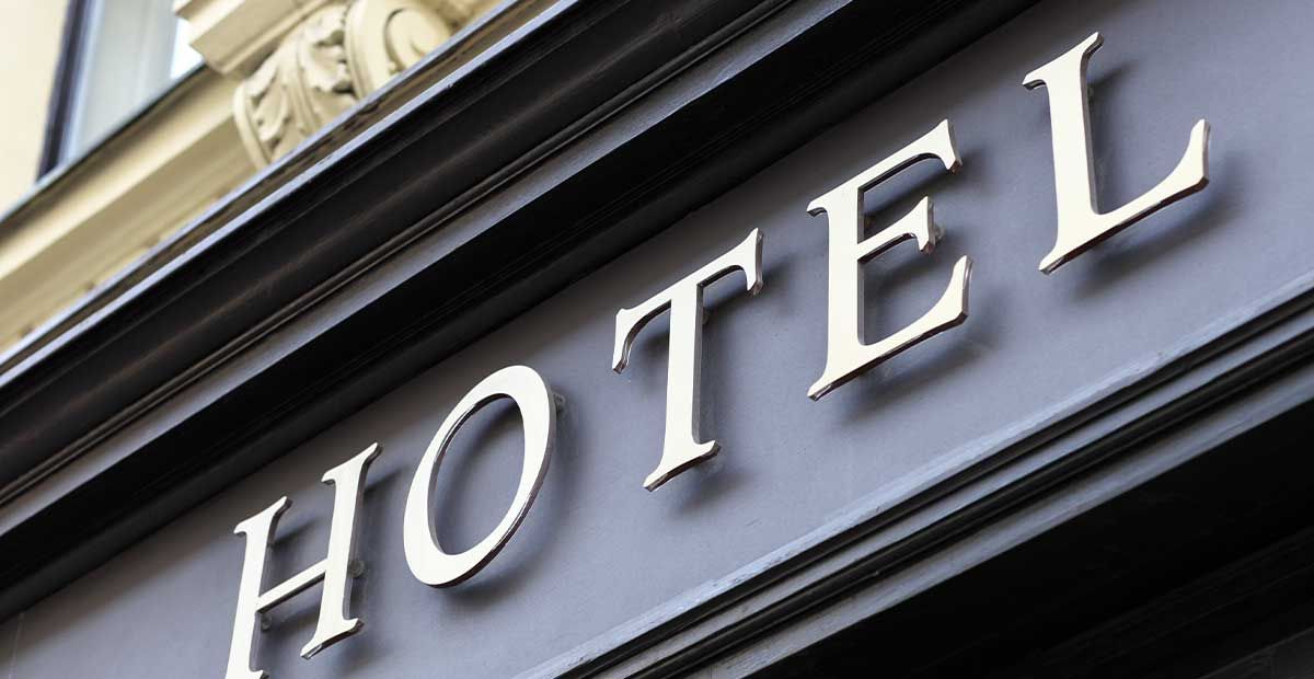 RME | Assetklasse Hotel: Goldener Schriftzug "Hotel" auf schwarzer Fassade